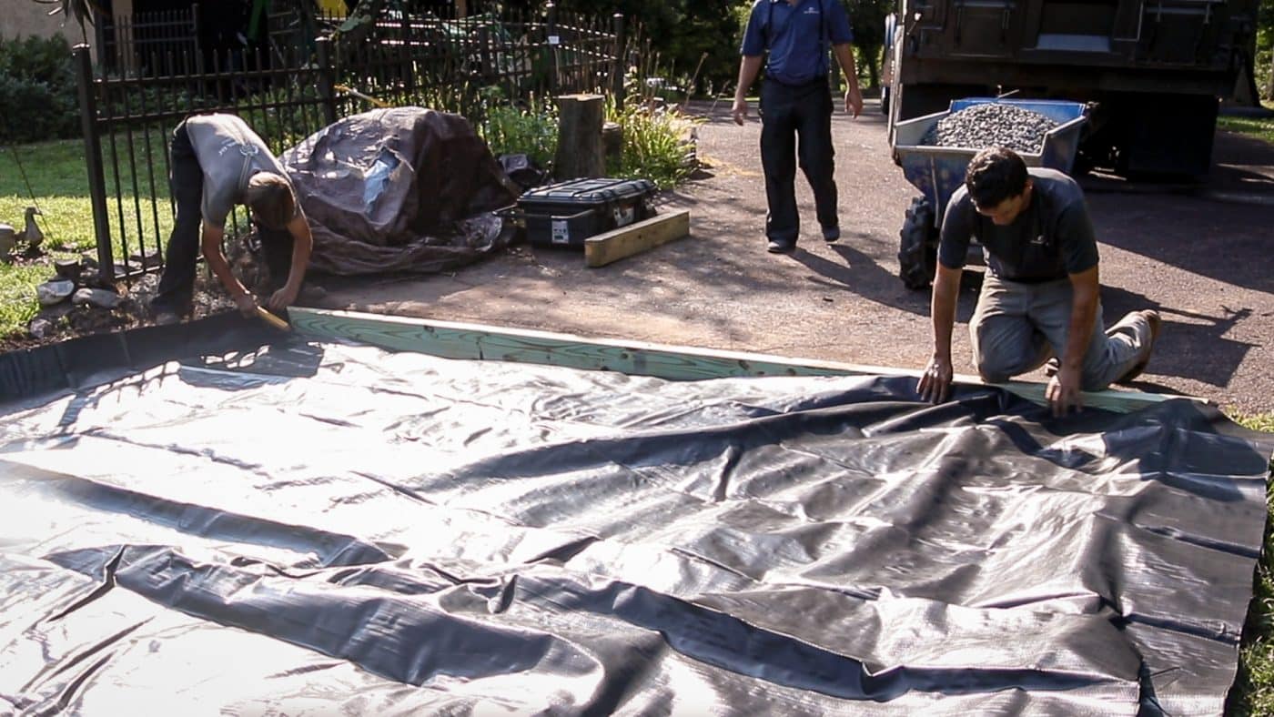 A shed site prep contractor in Ohio adding stabilization fabric to a shed foundation