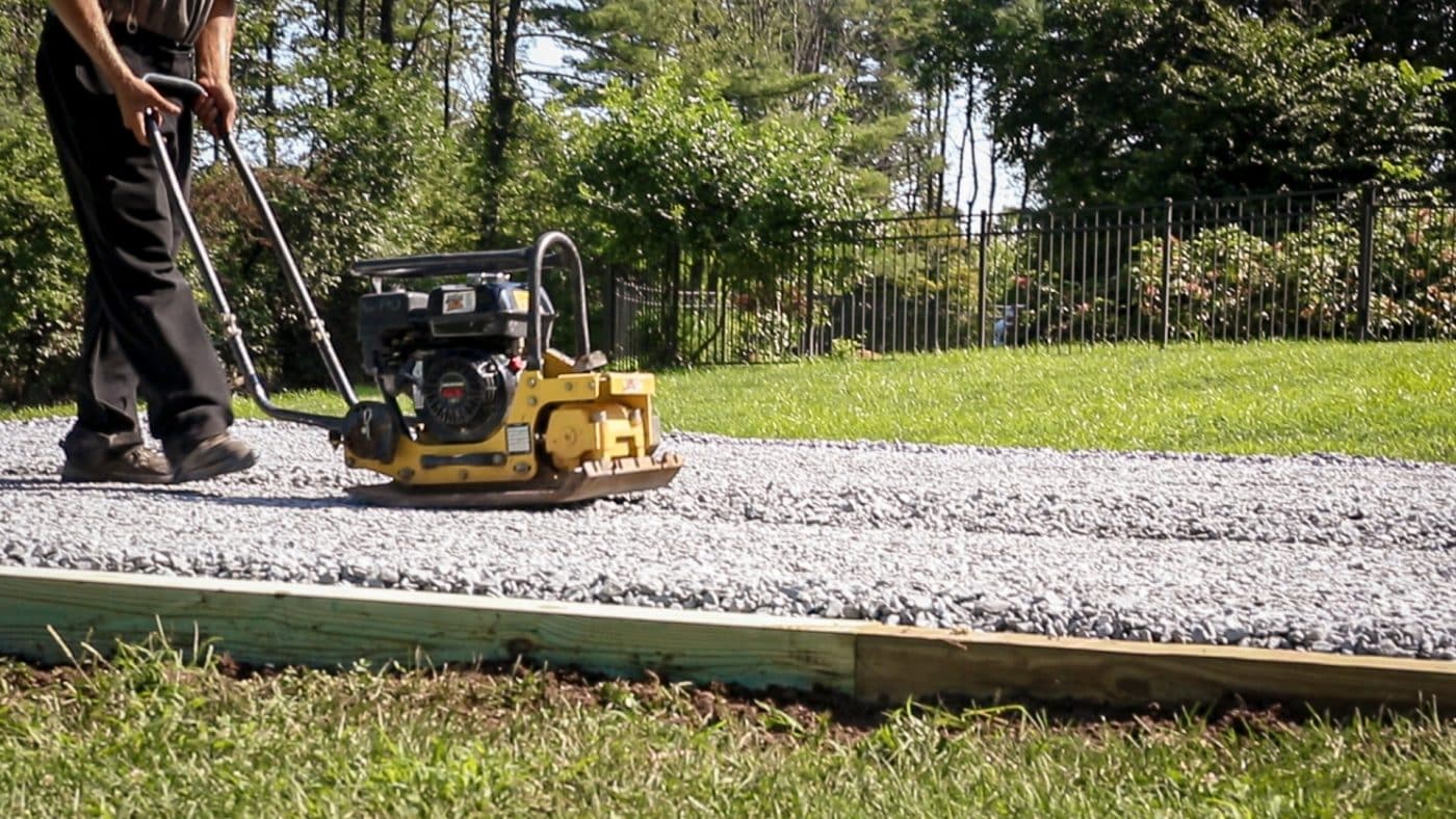 A shed foundation company in OH compacting gravel for a shed pad