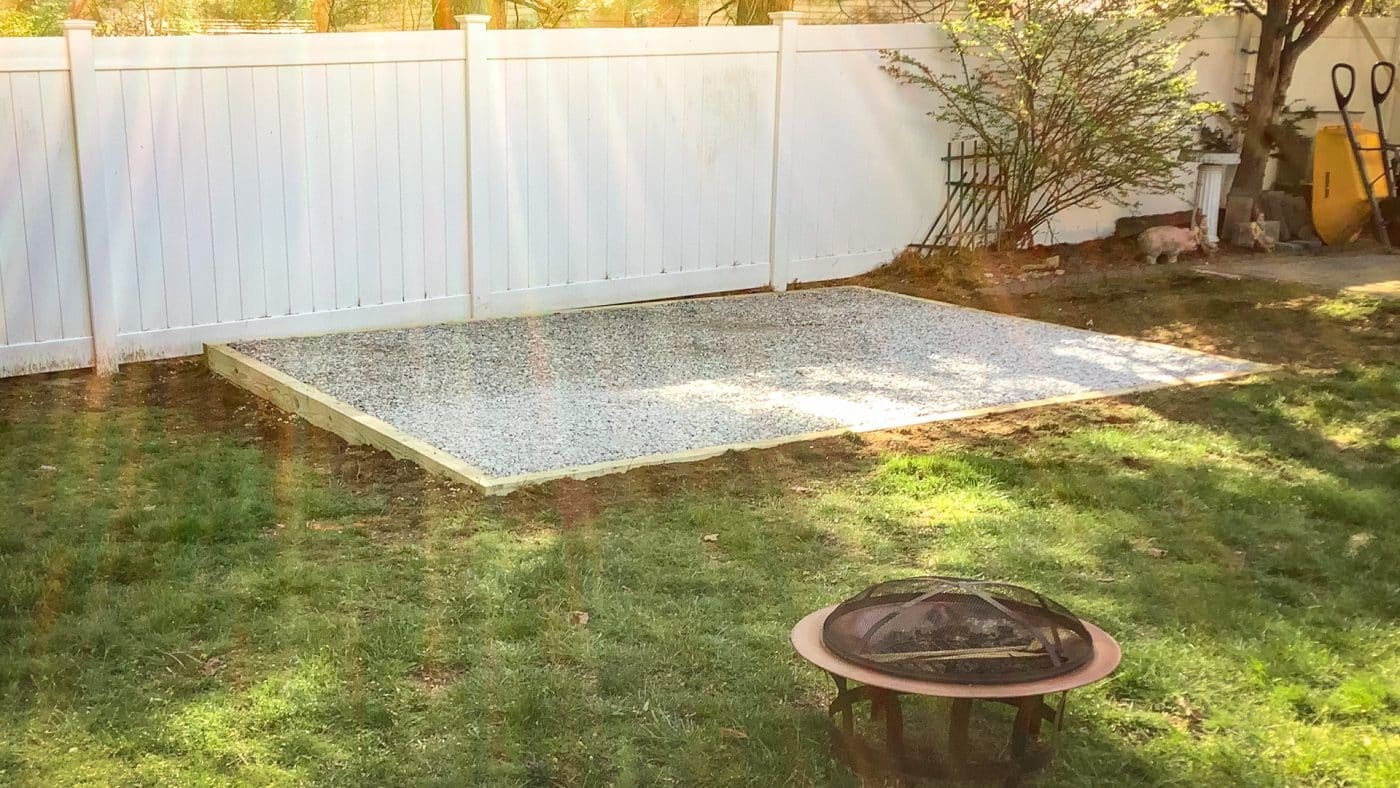 A fire pit gravel patio beside a privacy fence