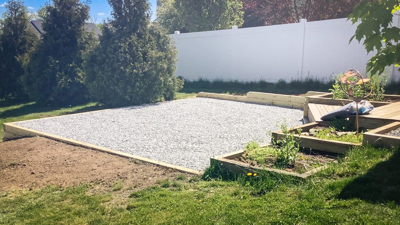 A gravel patio area in a backyard