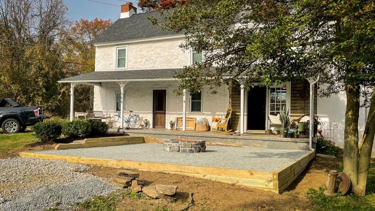 A gravel patio area for a fire pit beside a house