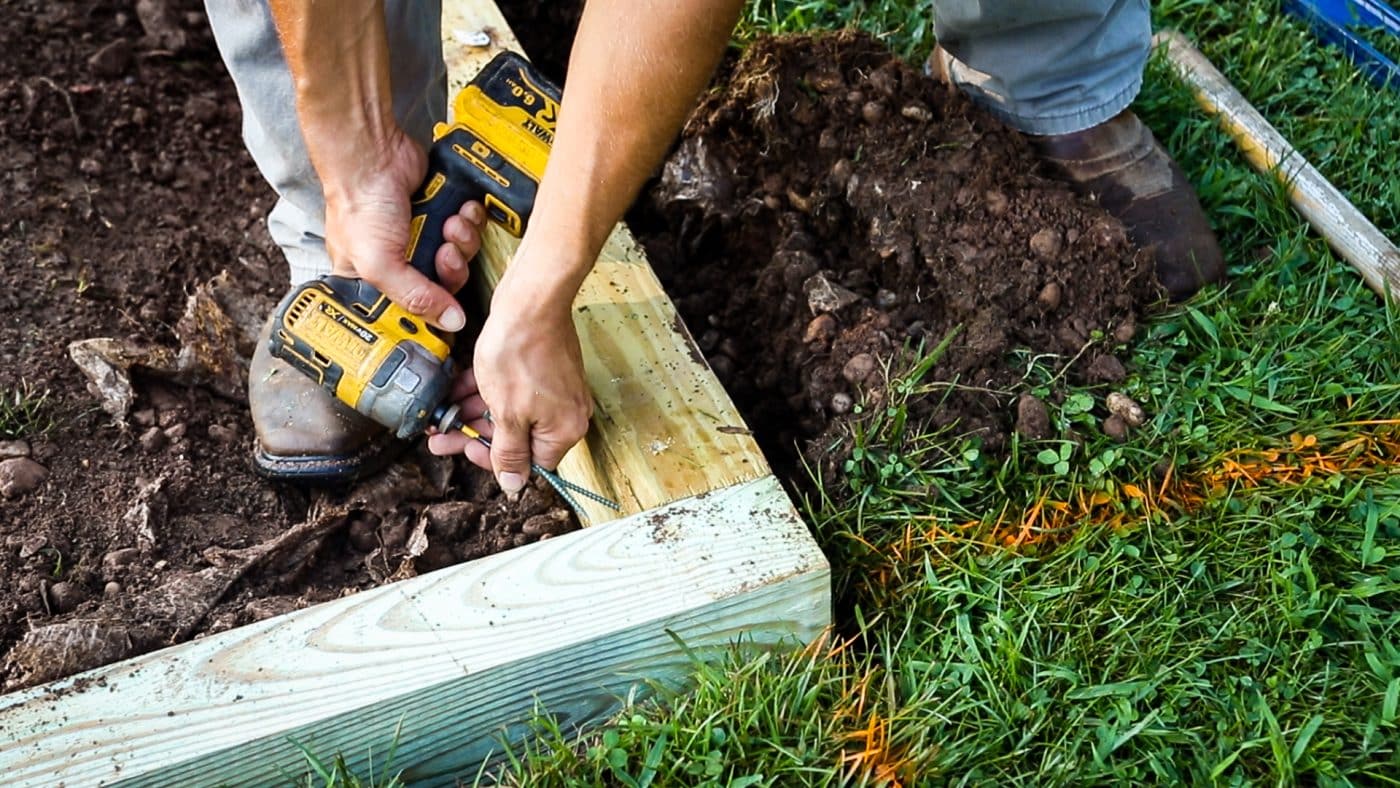 Installing a lumber perimeter for a gravel patio fire pit area