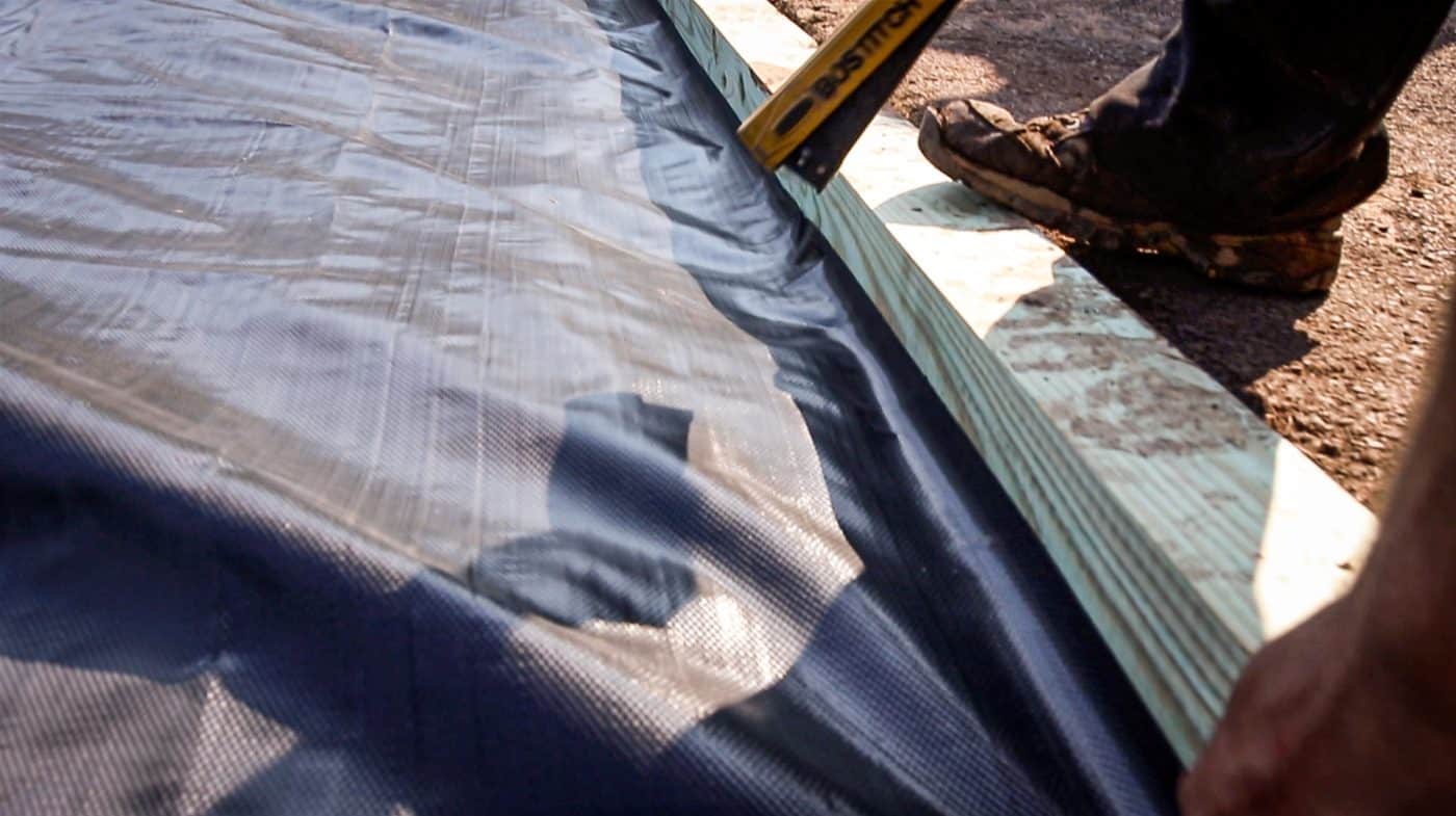 Weed barrier for gravel under a deck