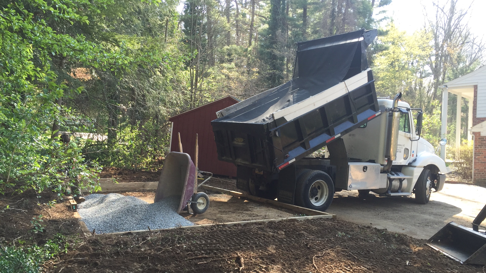 Spreading gravel in order to level the ground for a shed