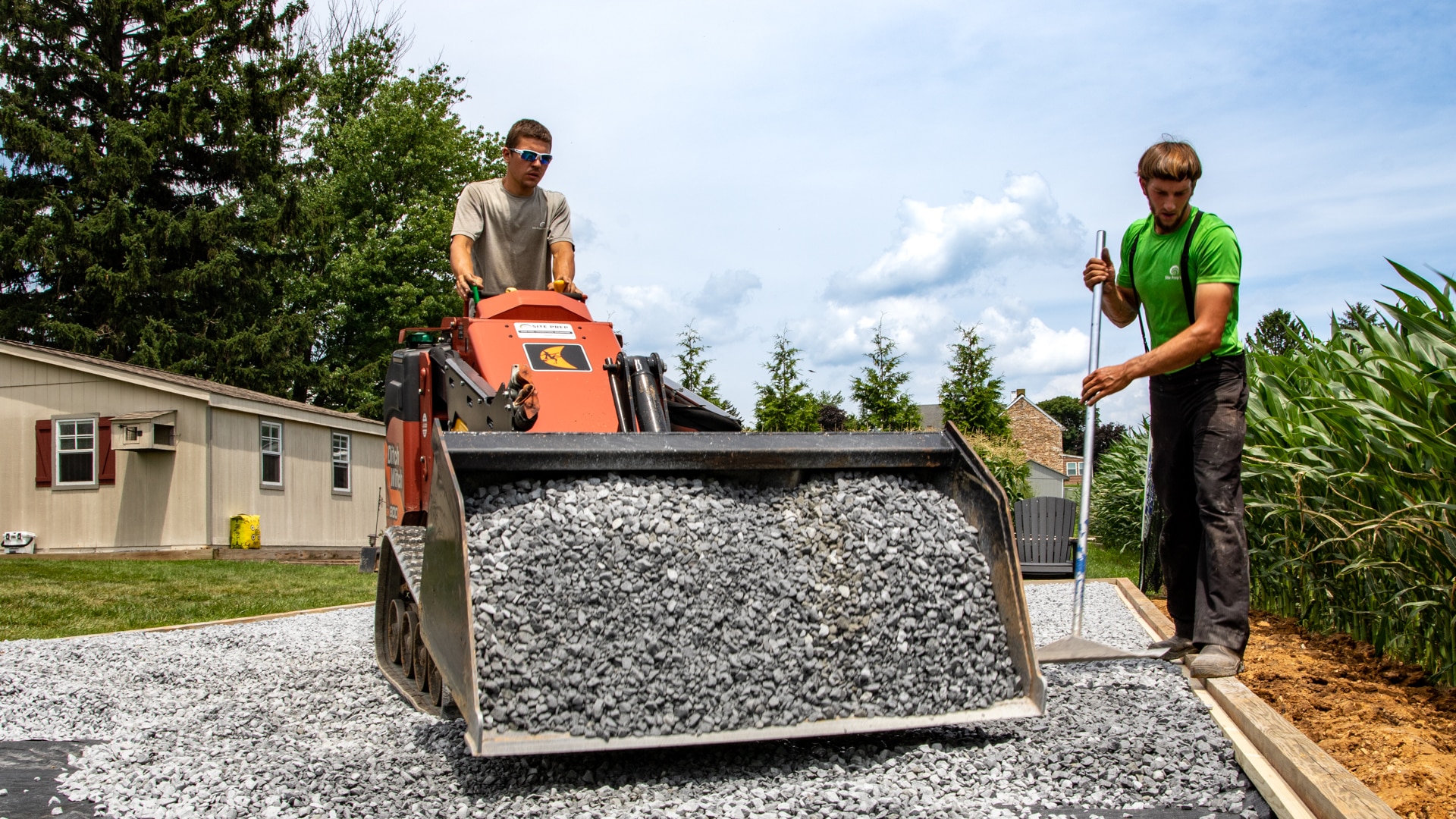 workers adding and raking stone for turf installation